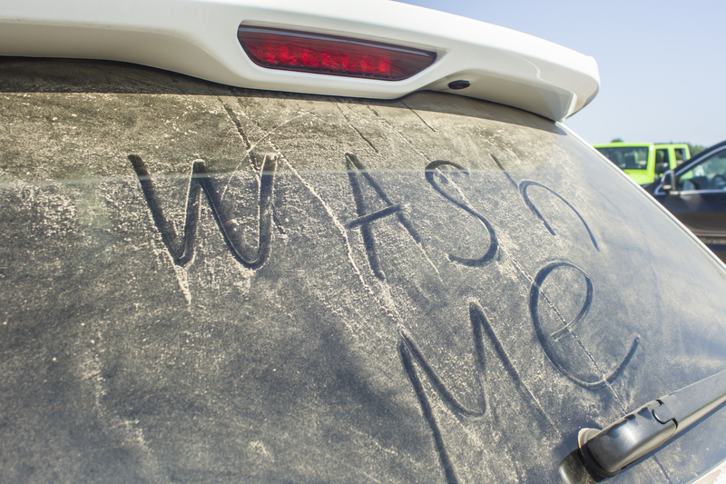 Back windshield of a car that says "wash me".