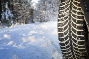 A close-up views of snow tires that have been driving in snow.