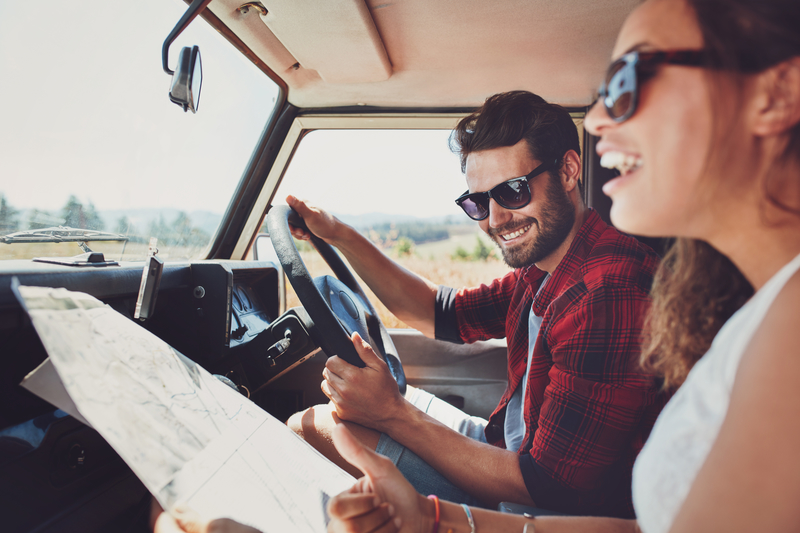 Young man and woman with a map going on a road trip. 